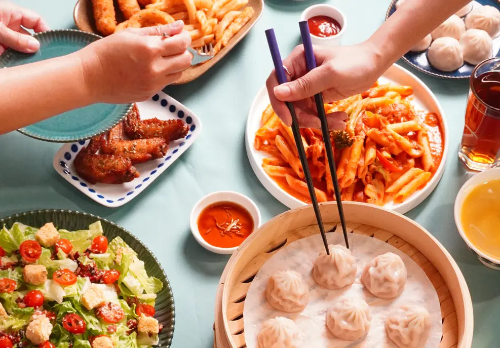 Supreme Dumplings' signature Taiwanese soup dumplings, co-developed by former Din Tai Fung and W Hotel chefs, perfectly plated alongside pasta, salad, and fried chicken for a versatile family feast.